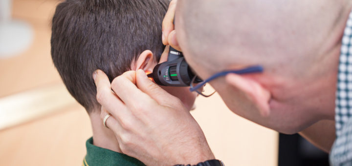 Examining the ear with an otoscope.