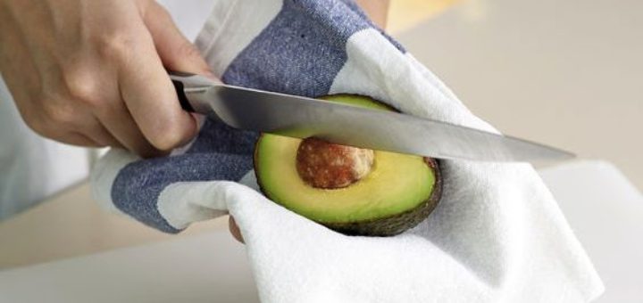 Hand using knife to get rid off avocado seed